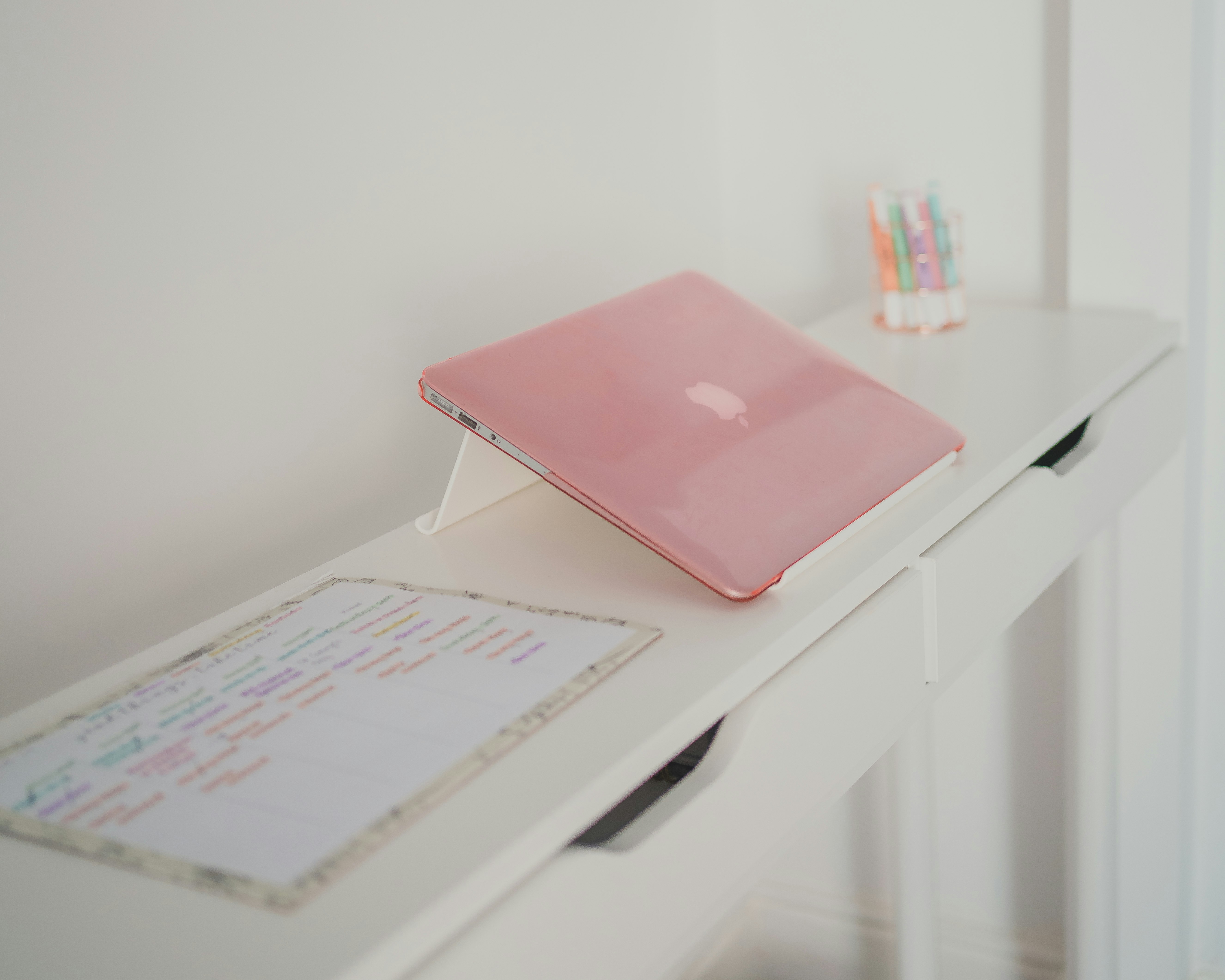 pink laptop computer on white table